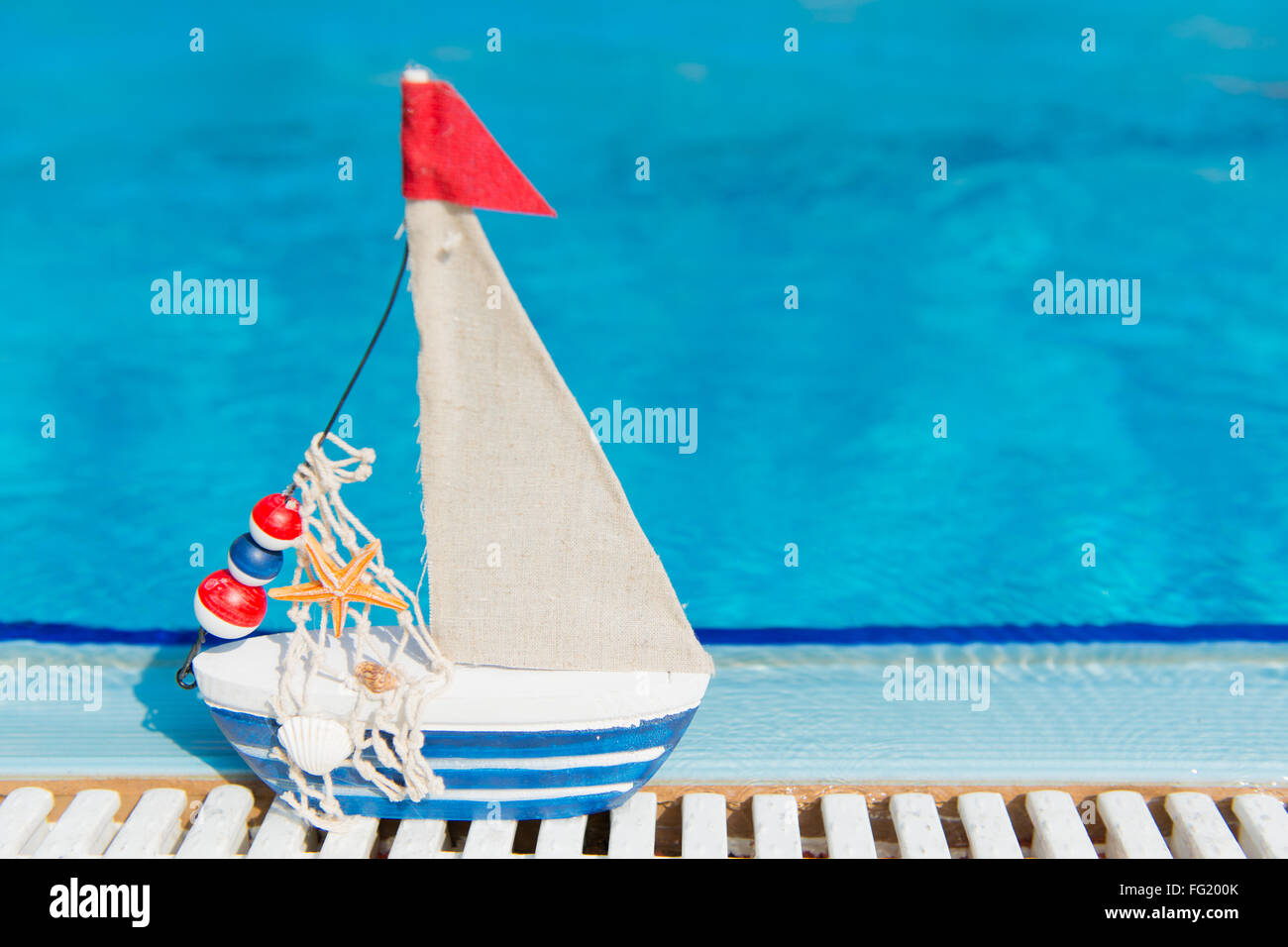 Barca in miniatura come giocattolo presso la piscina Foto Stock