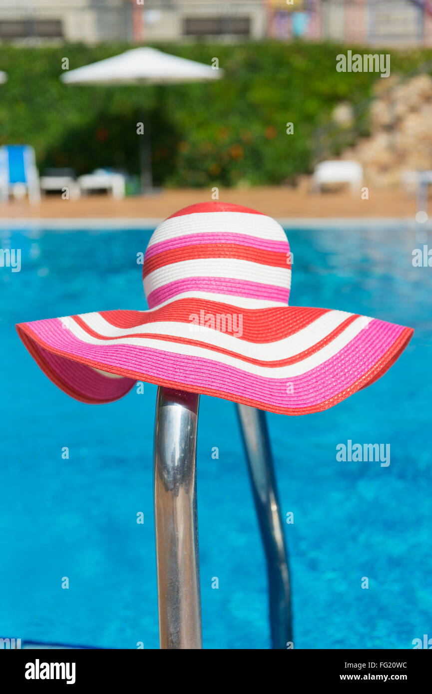 Piscina di lusso con femmina rosa cappello per il sole Foto Stock