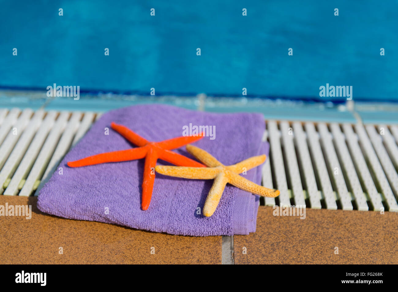 Asciugamano e star pesci presso la piscina Foto Stock