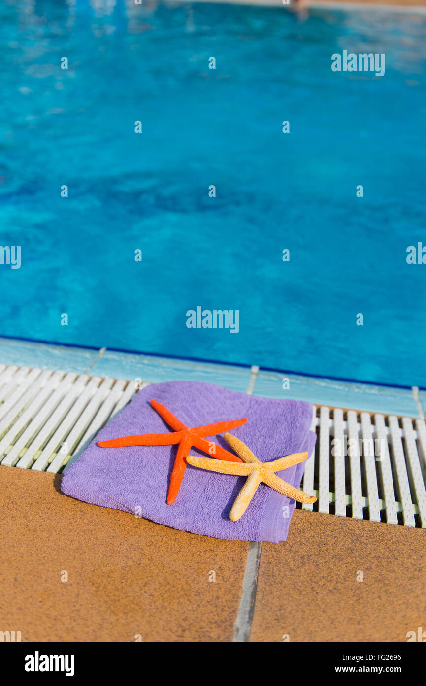 Asciugamano e star pesci presso la piscina Foto Stock