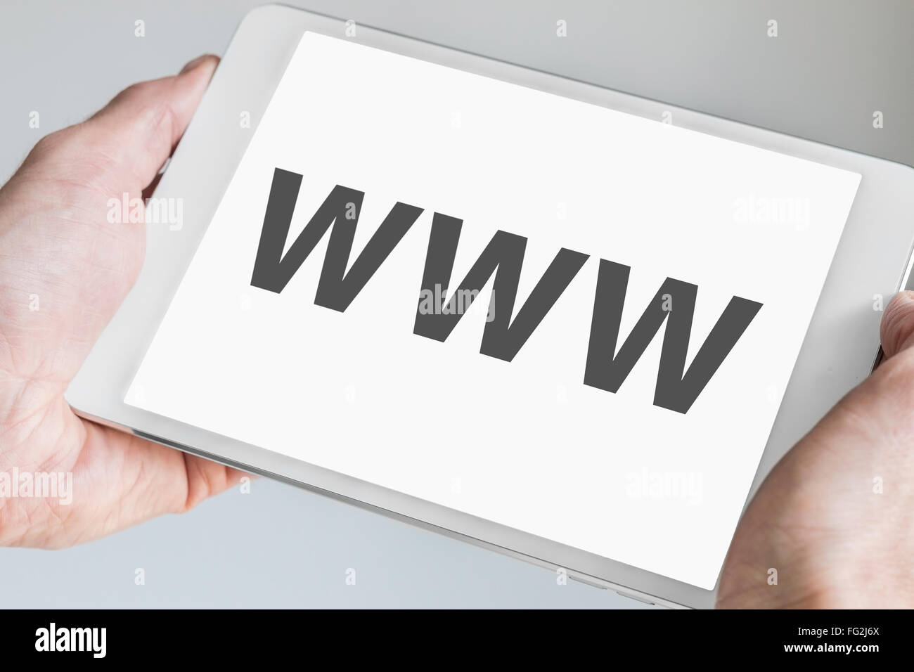 WWW (World wide web) il testo visualizzato sullo schermo a sfioramento della moderna tablet. Mani bianche del dispositivo mobile Foto Stock