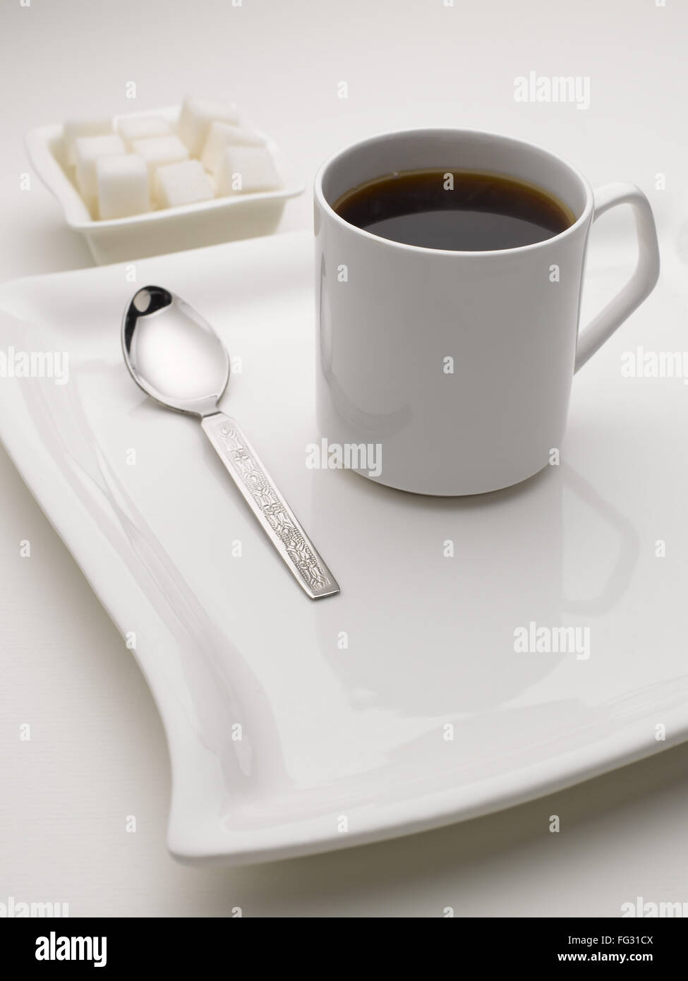 La tazza di tè nero in piatto con cubetti di zucchero India Foto Stock
