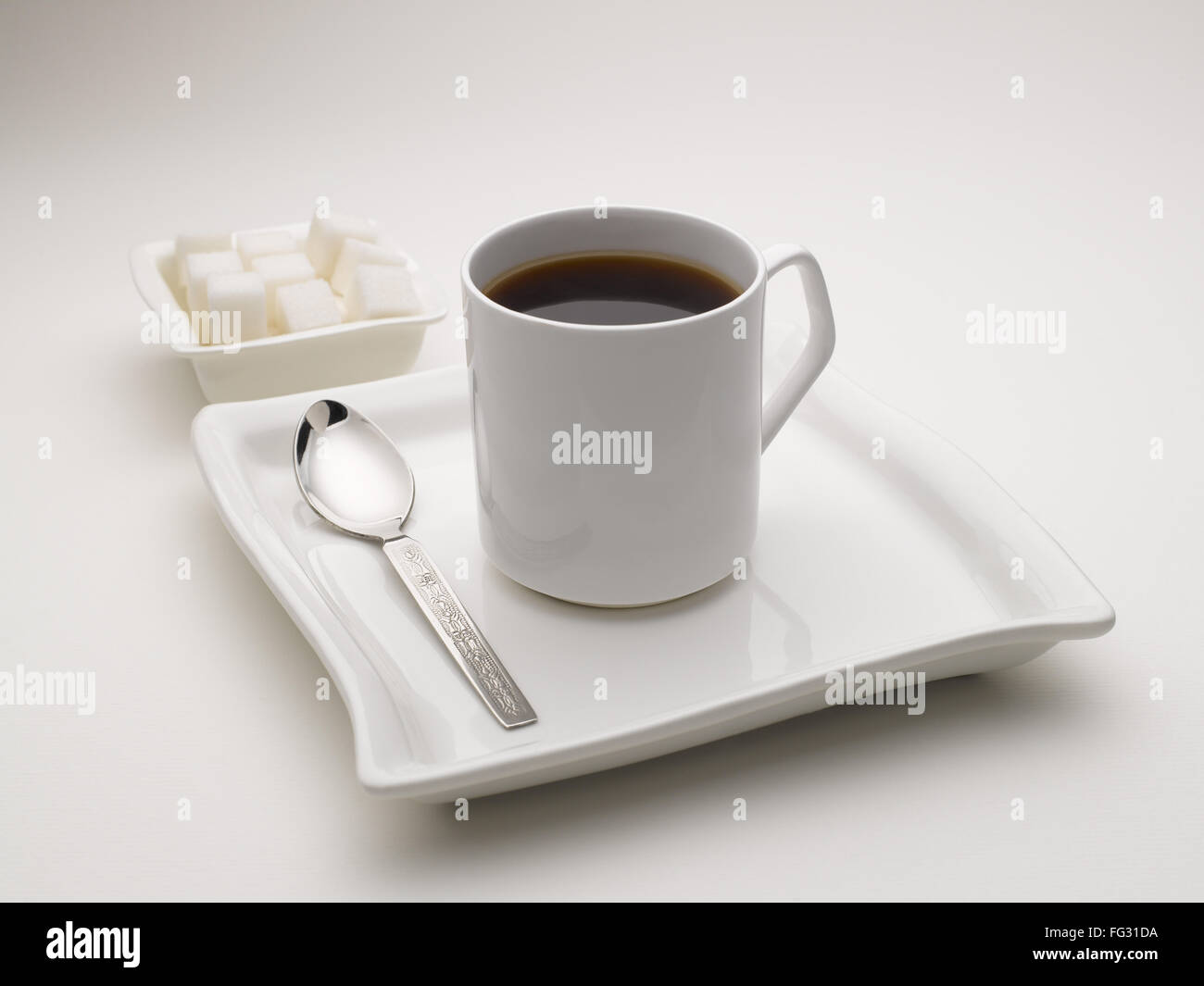 La tazza di tè nero in piatto con cubetti di zucchero India Foto Stock