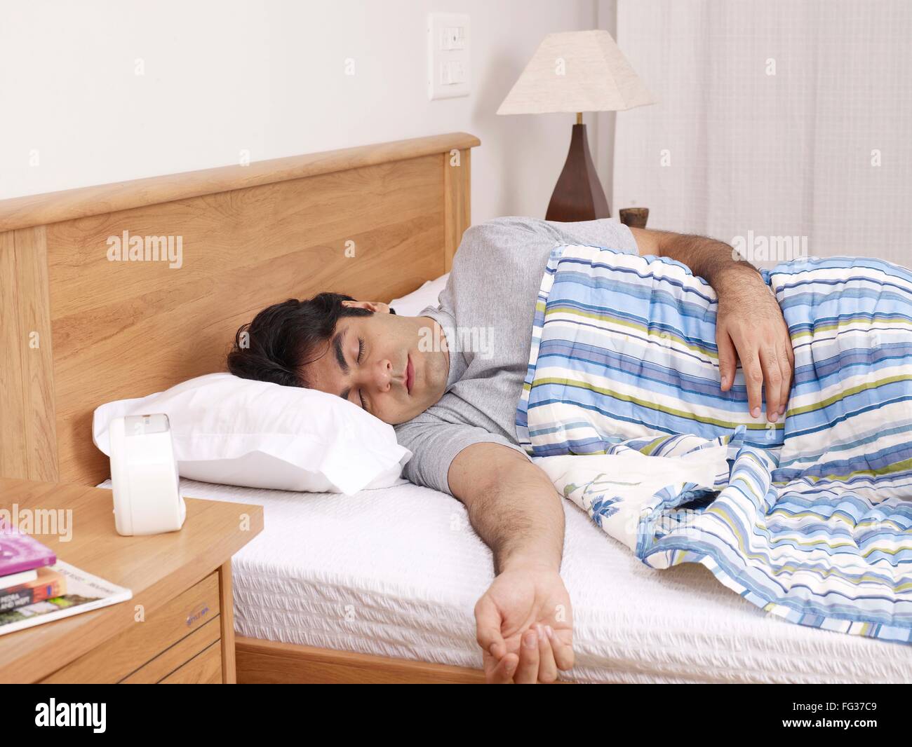 Giovane uomo avente suono addormentato sul letto signor#702V Foto Stock