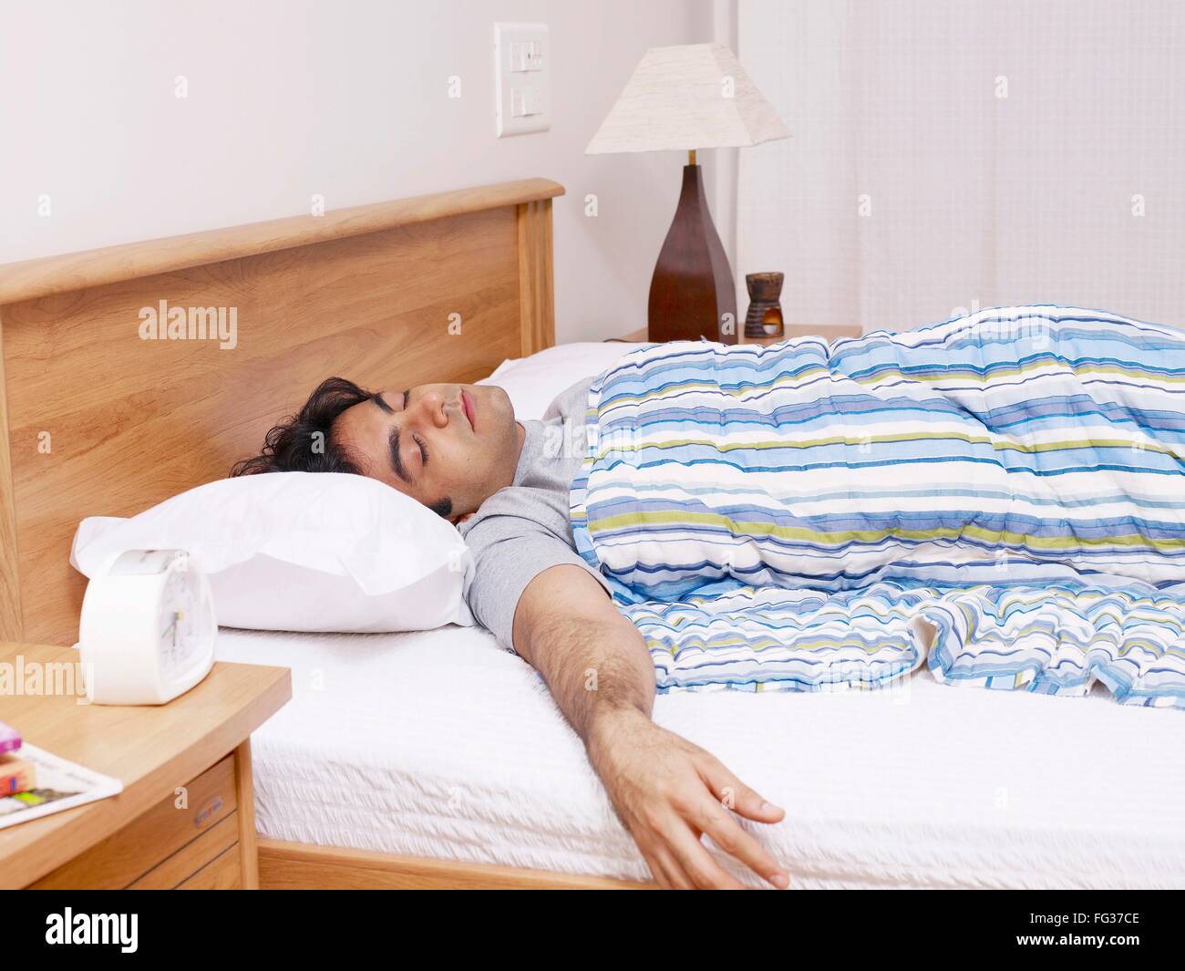Giovane uomo avente suono addormentato sul letto signor#702V Foto Stock