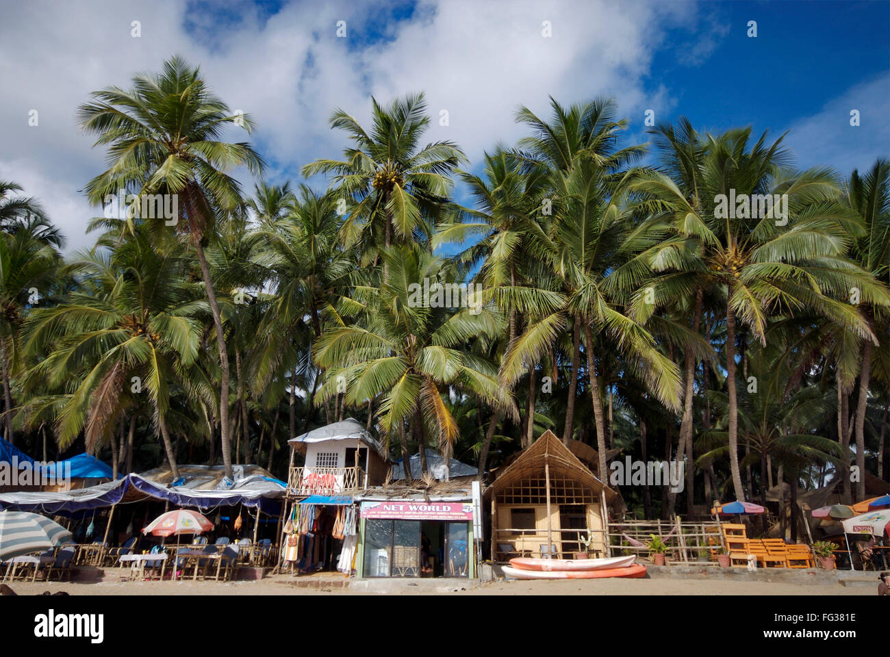 Baracche sotto gli alberi di cocco e barche a Palolem beach , Goa , India Foto Stock