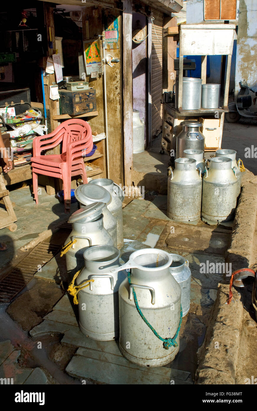 Red sedie di plastica e alluminio lattine di latte in Mahesh Dairy Doodh Kendra ; Bhuj ; ; Kutch Gujarat ; India Foto Stock