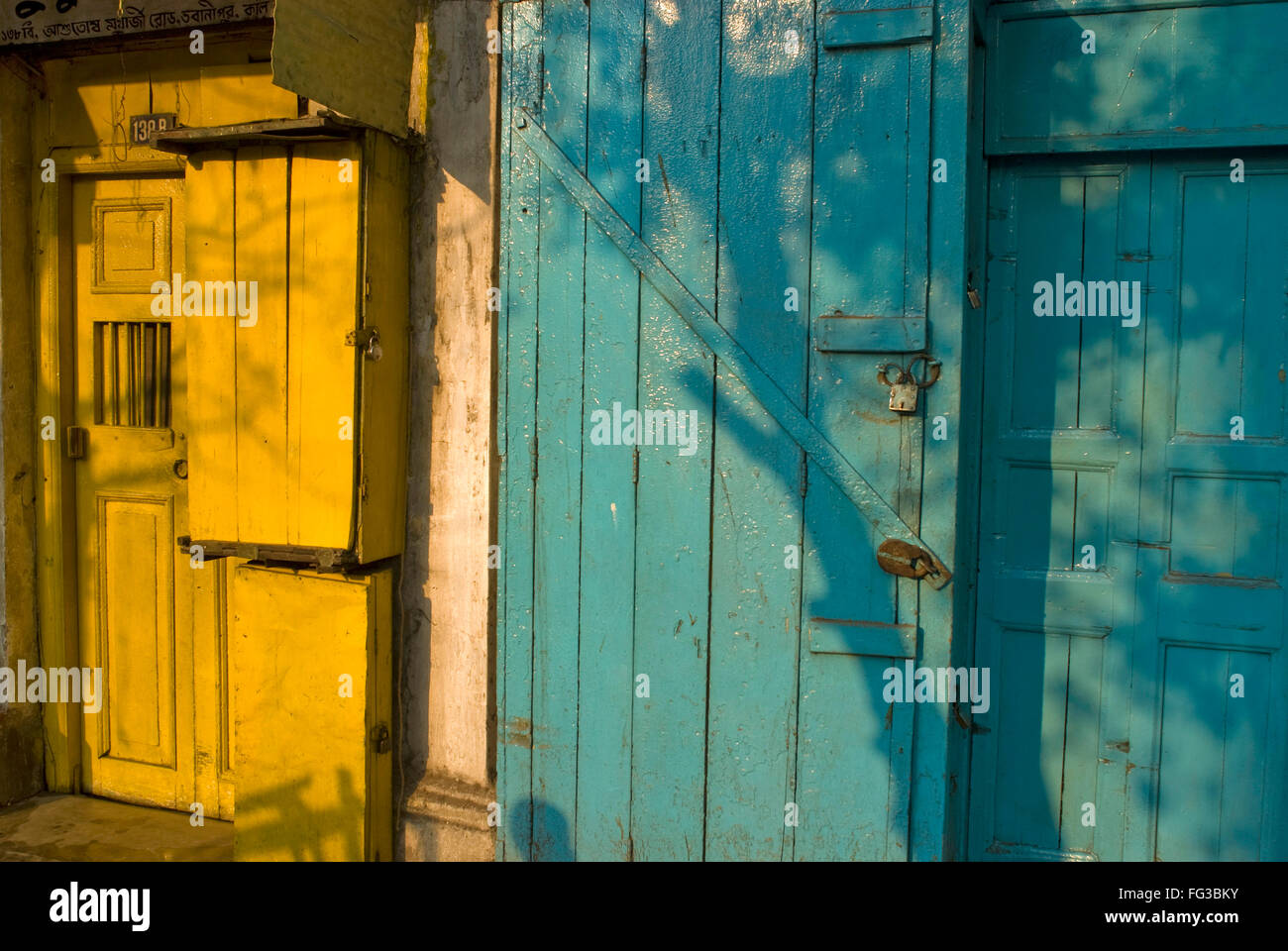 Vecchio di legno giallo e blu le porte chiuse ; Bhowanipur ; Calcutta ; Bengala Occidentale ; India Foto Stock