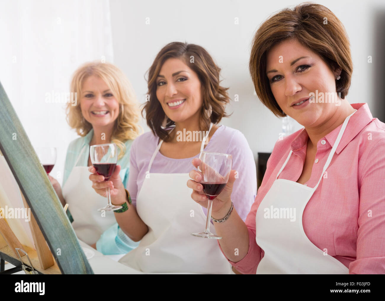 Tre donne azienda vino in vetro art studio Foto Stock