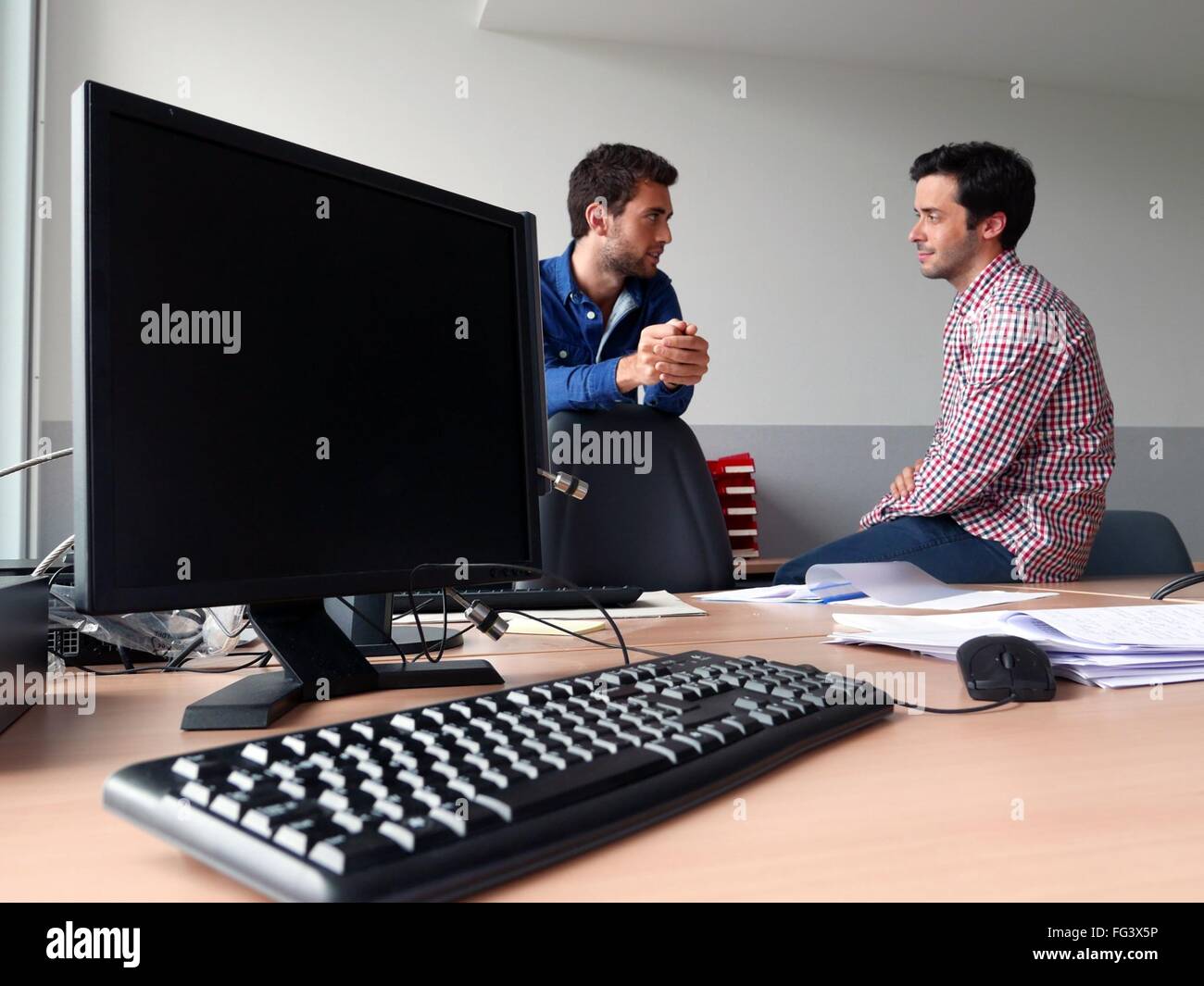 Gli uomini a discutere in ufficio Foto Stock