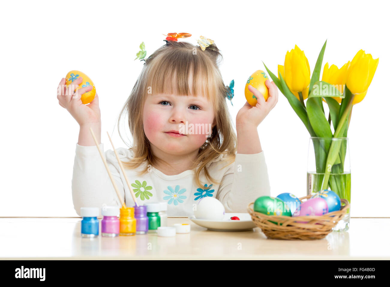 Bambino ragazza con spazzola per colorare le uova di pasqua Foto Stock