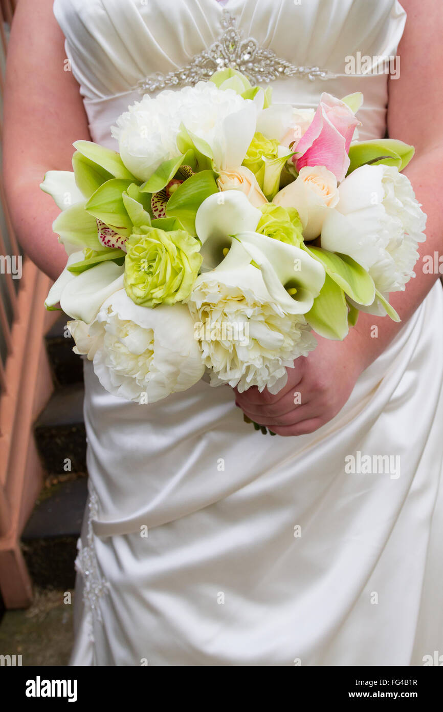 Sposa tenendo il suo bouquet di fiori su un giorno di nozze. Foto Stock