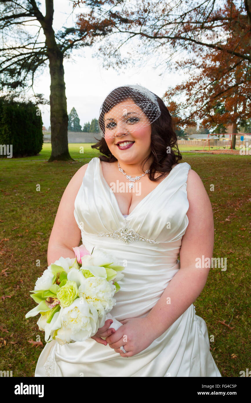Sposa il giorno delle nozze in posa lungo per un ritratto in esterno e in Oregon. Foto Stock