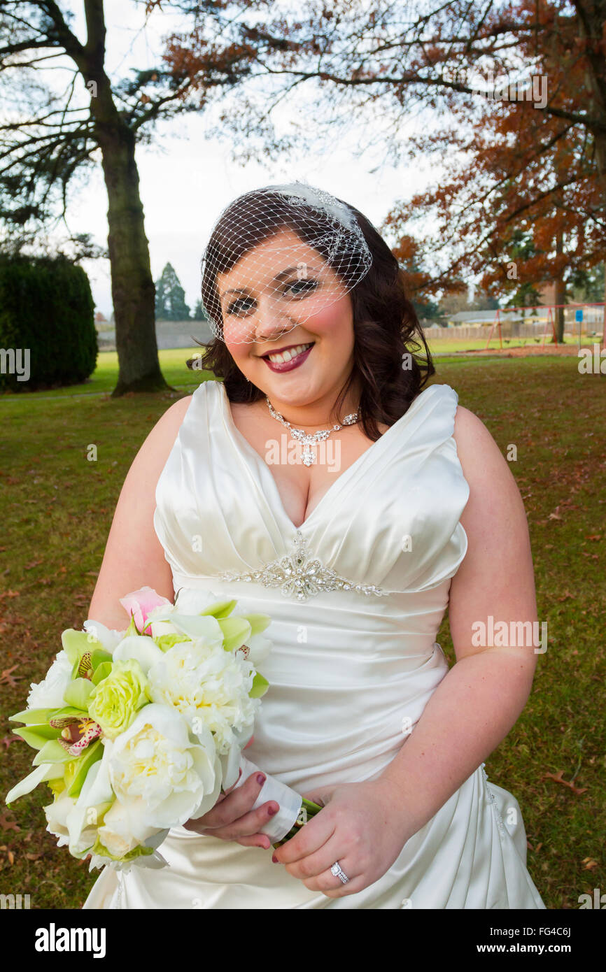 Sposa il giorno delle nozze in posa lungo per un ritratto in esterno e in Oregon. Foto Stock