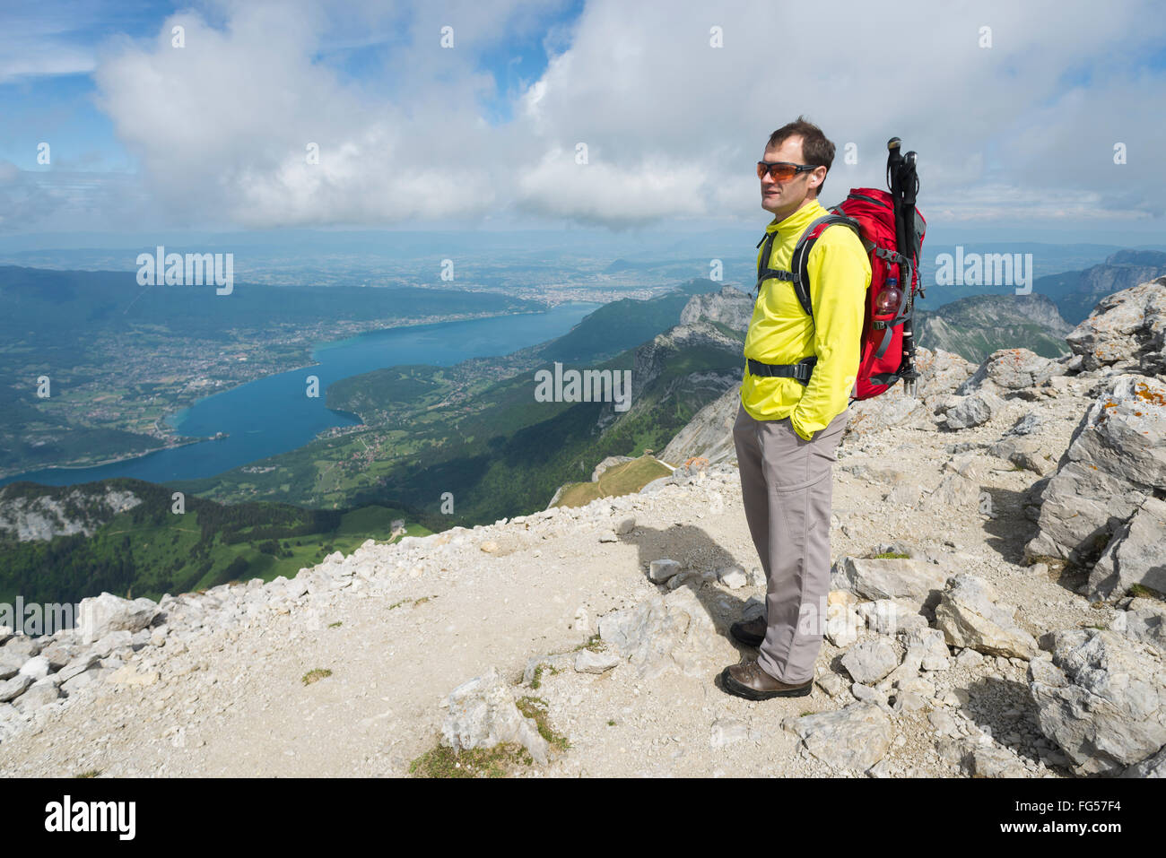 Escursionista maschio in piedi sulla cima del monte Tournette cercando di montagna sopra il lago di Annecy panorama alpino, Savoy,Francia Foto Stock