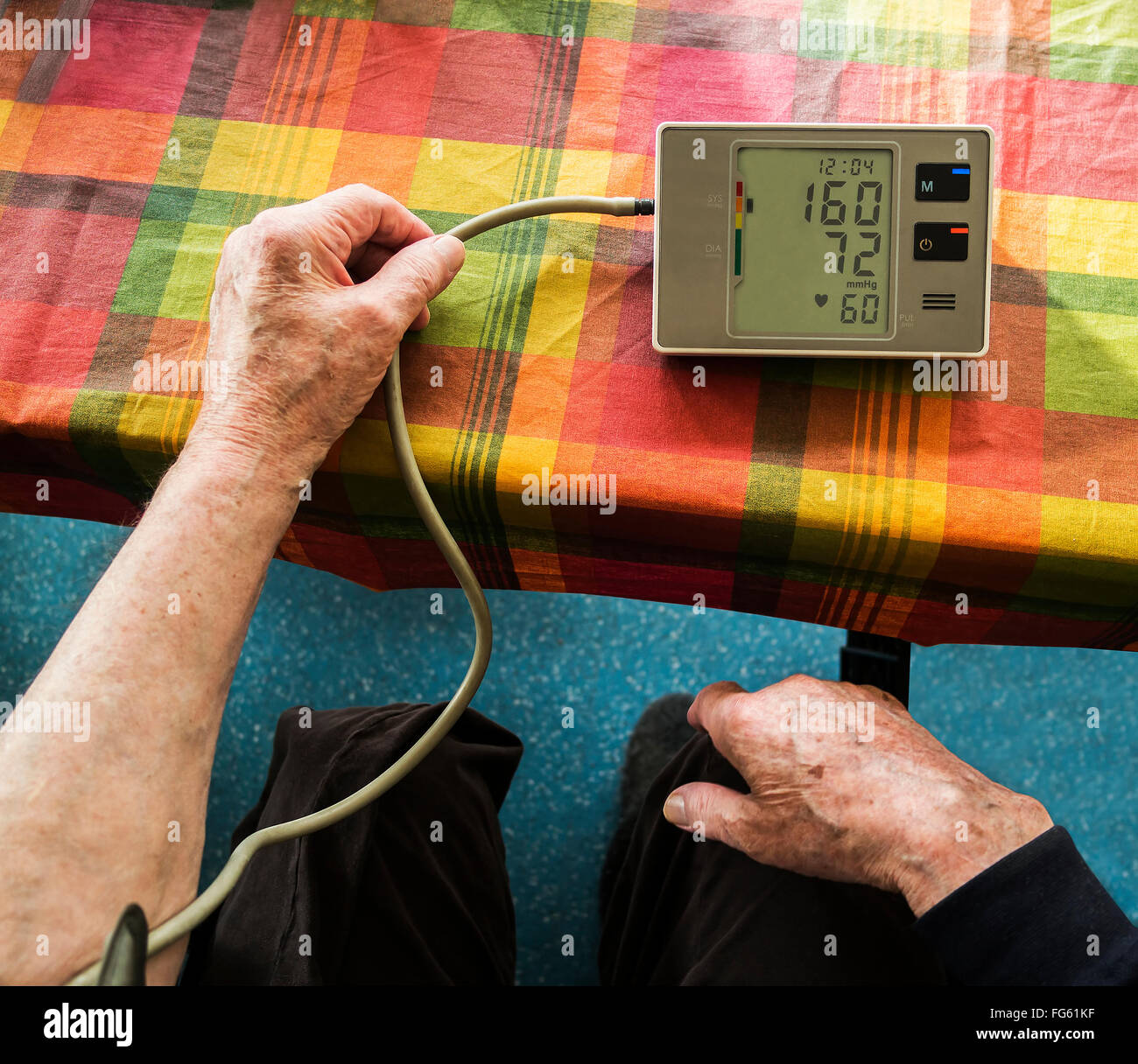 Vecchia persona è di misurare la pressione sanguigna con una gamba mancante. Foto Stock