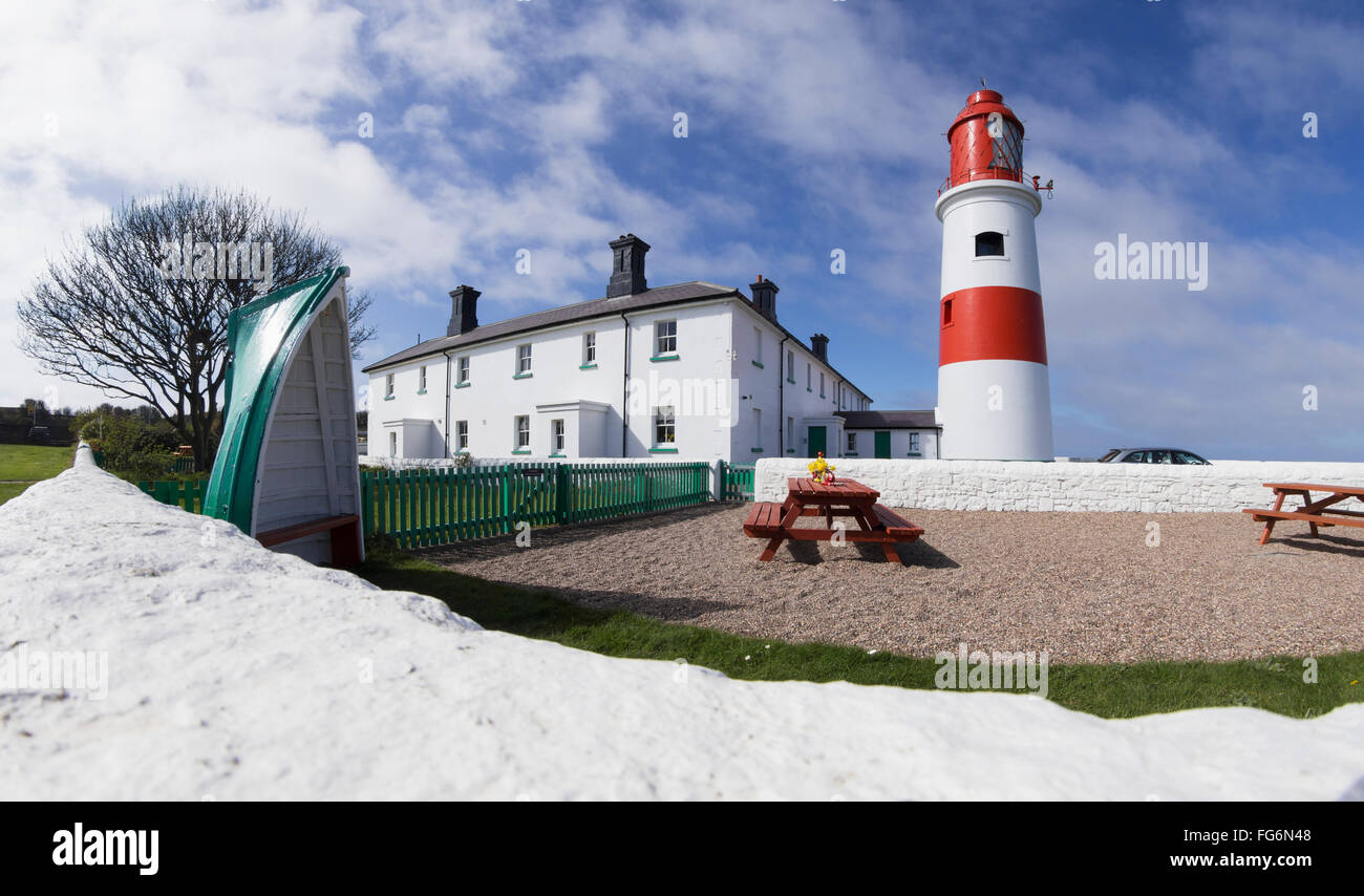 Un percorso di bianco accanto a un rosso e bianco e faro edificio, tavoli da picnic in un area con posti a sedere; South Shields, Tyne and Wear, Inghilterra Foto Stock