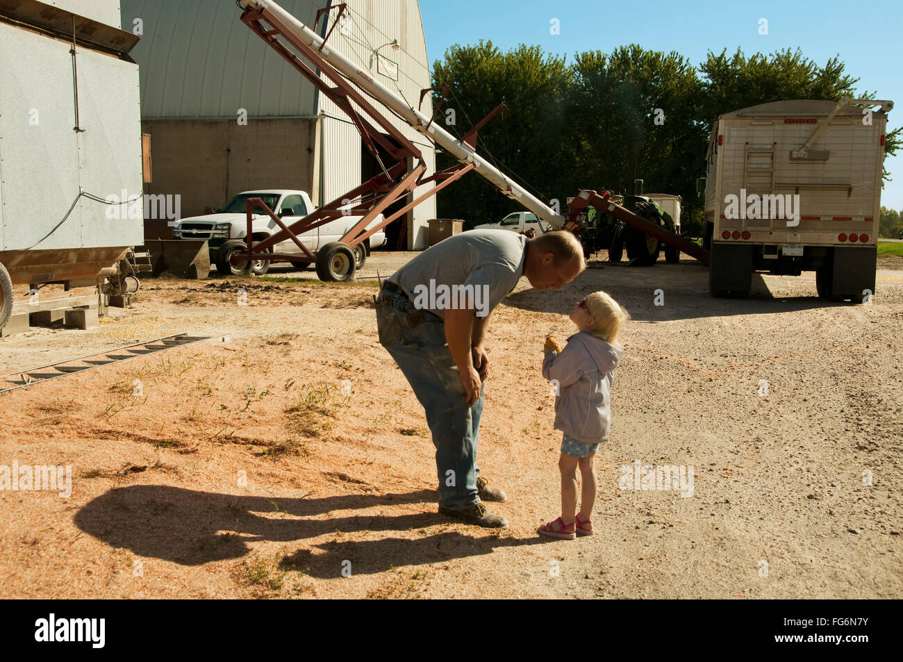 Agricoltura - Un coltivatore e la sua figlia giovane Condividi Un momento insieme durante il suo giorno di lavoro di raccolta e stoccaggio grano granturco / vicino Sioux City, I... Foto Stock