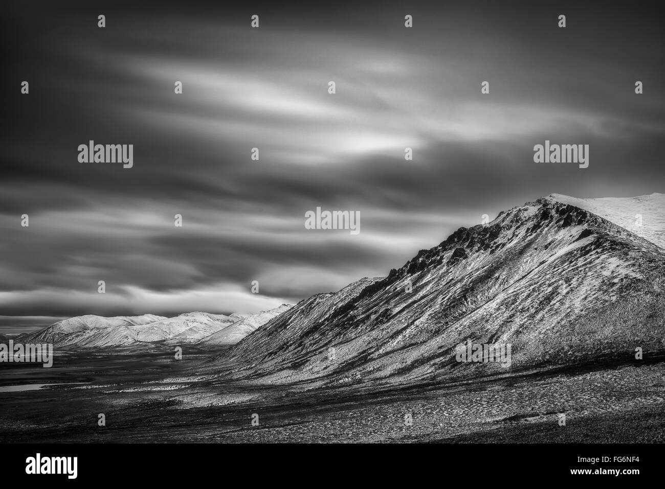 In bianco e nero lunga esposizione di nuvole sopra la gamma nuvoloso lungo la Dempster Highway; Yukon, Canada Foto Stock