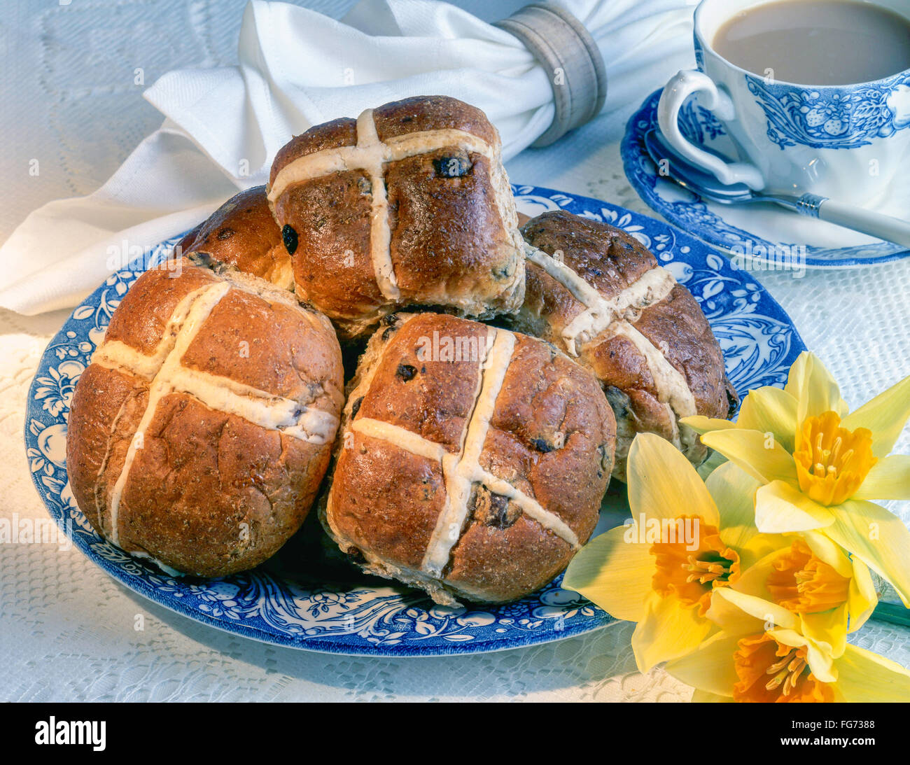 Hot cross panini sulla piastra con la tazza di tè in studio di impostazione Foto Stock