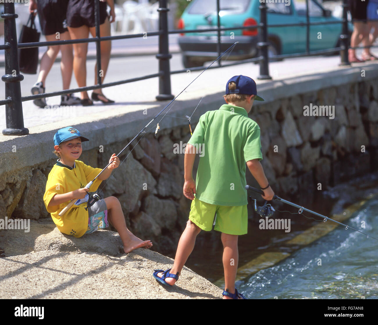 I ragazzi con attività di pesca in porto, Es Cana, Ibiza, Isole Baleari, Spagna Foto Stock
