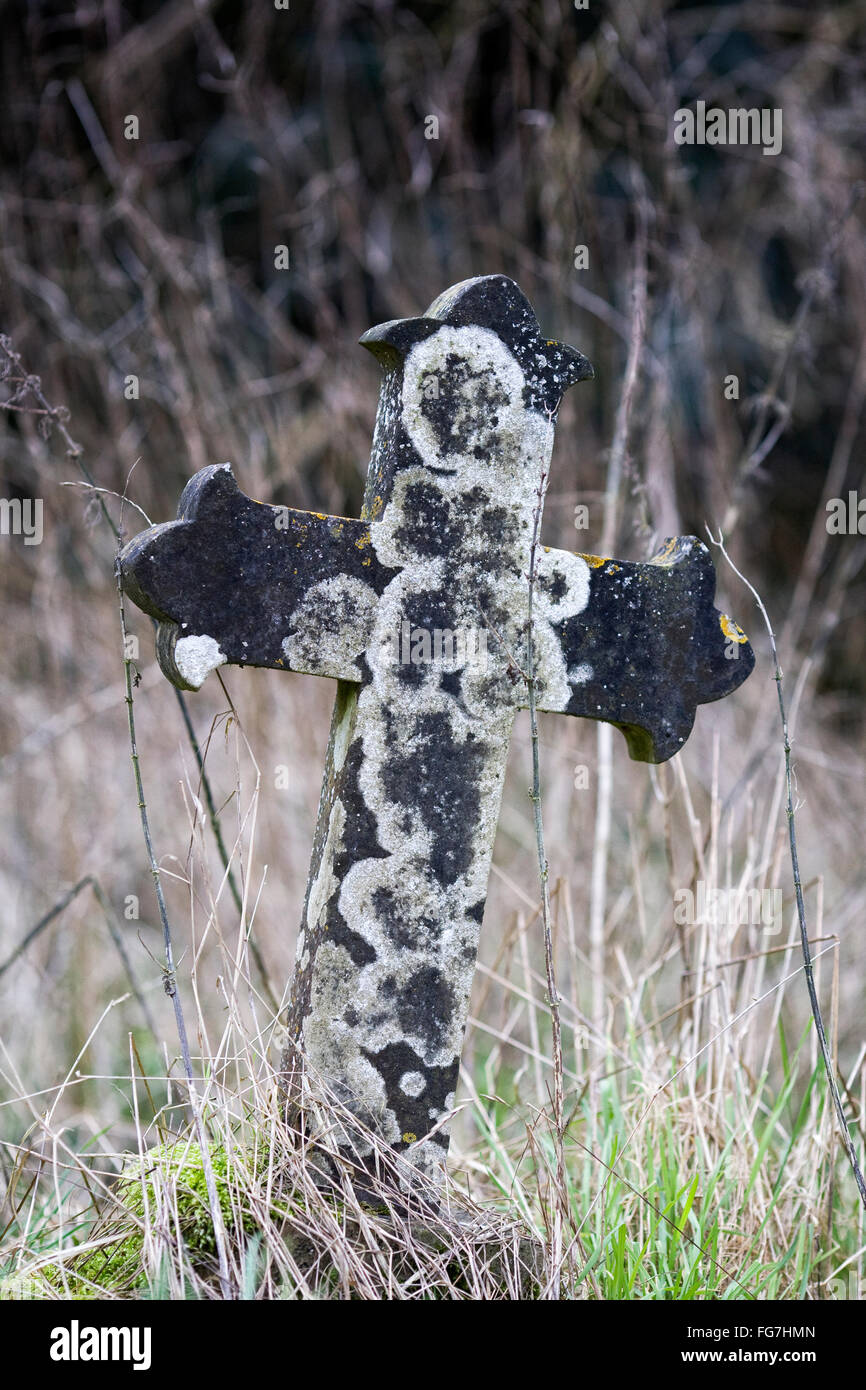 Antica croce di pietra in un cimitero. Foto Stock