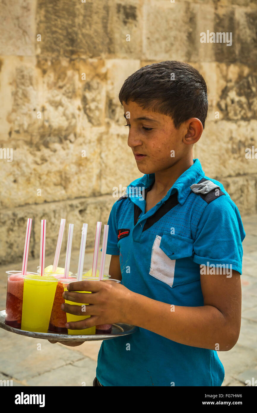 Un giovane ragazzo che serve rinfreschi presso il teatro romano nella vecchia città di Amman, Regno Hascemita di Giordania, Medio Oriente. Foto Stock