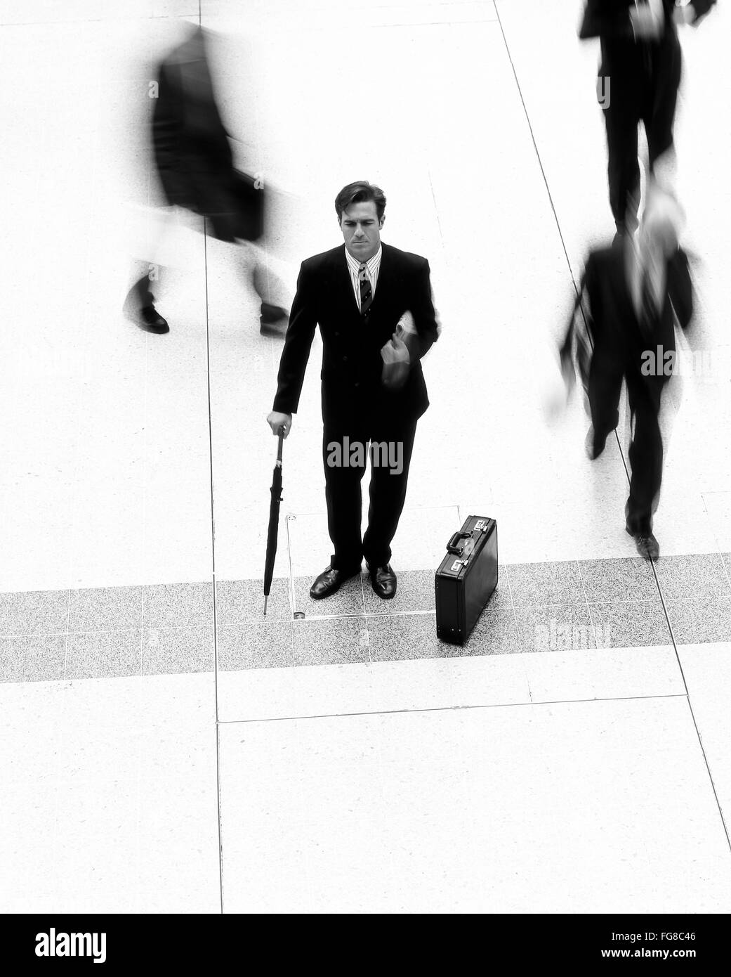 Città giovane uomo d affari in attesa nella stazione di Liverpool Street, City of London, Londra, Inghilterra, Regno Unito Foto Stock