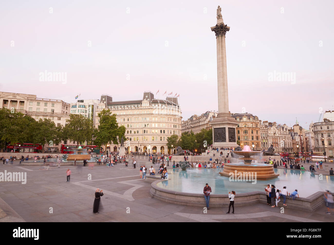 Trafalgar Square con le persone e i turisti al tramonto a Londra Foto Stock