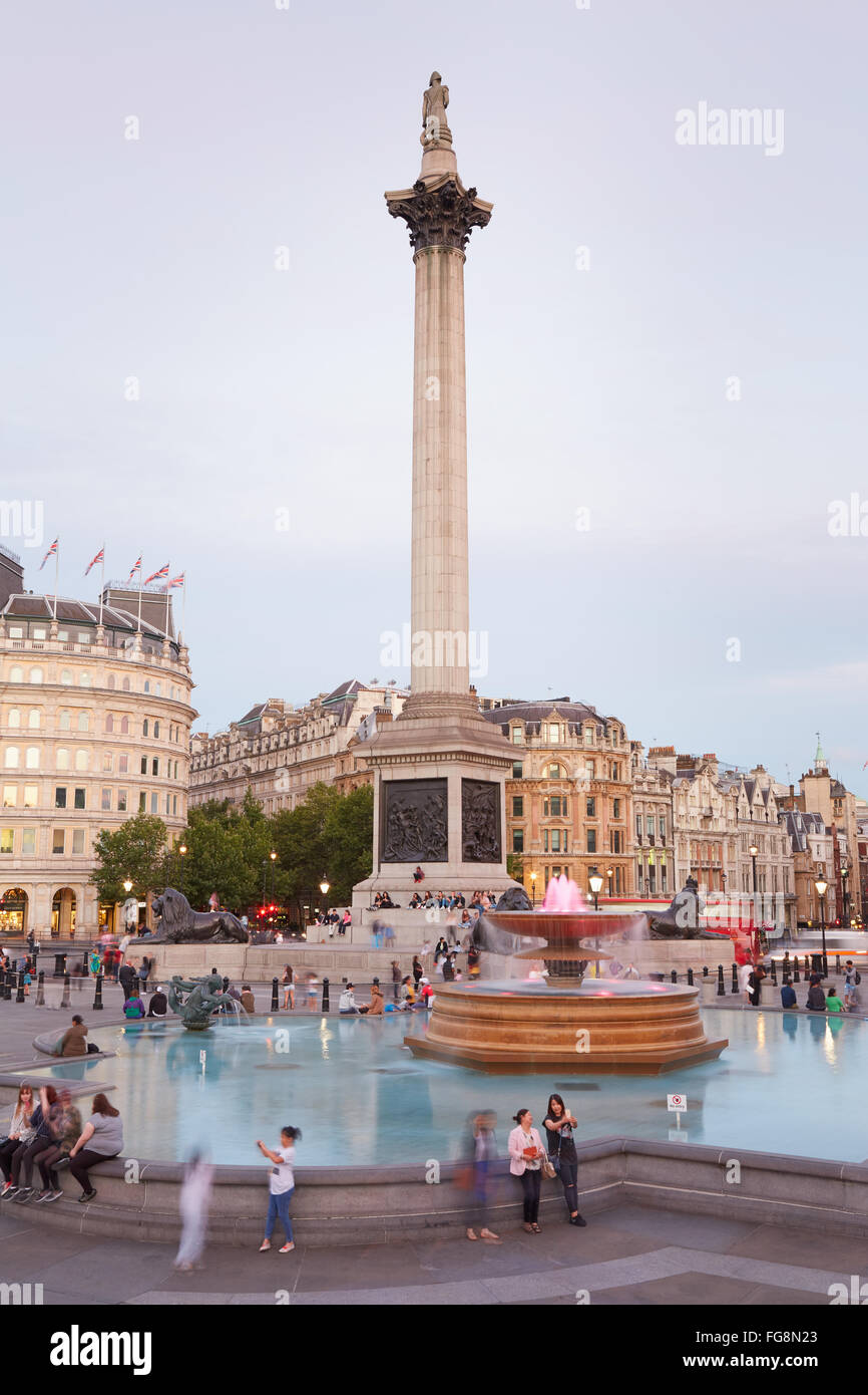 Trafalgar Square con le persone e i turisti al tramonto a Londra Foto Stock