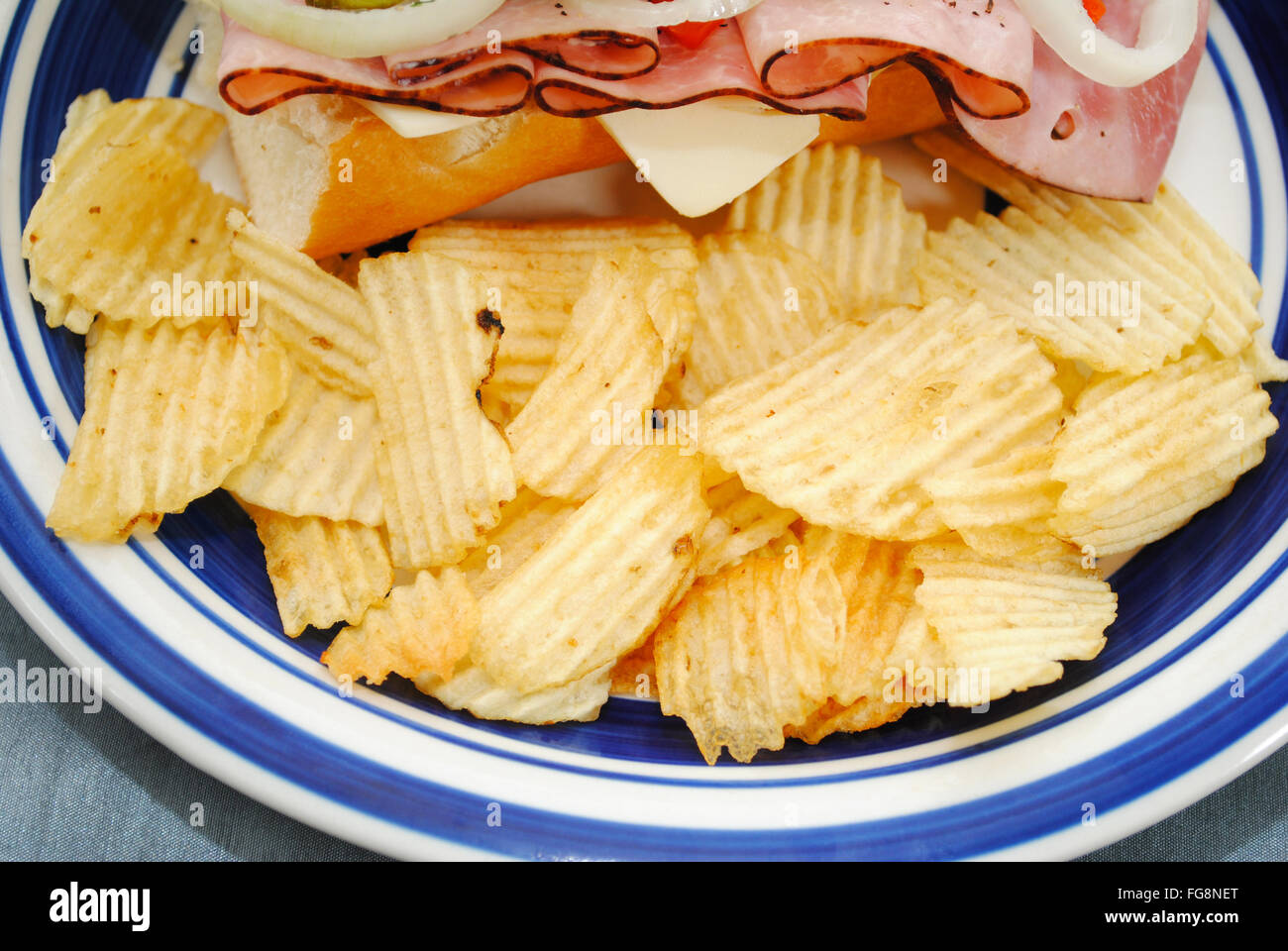 Increspato patatine fritte servite con un sandwich Foto Stock