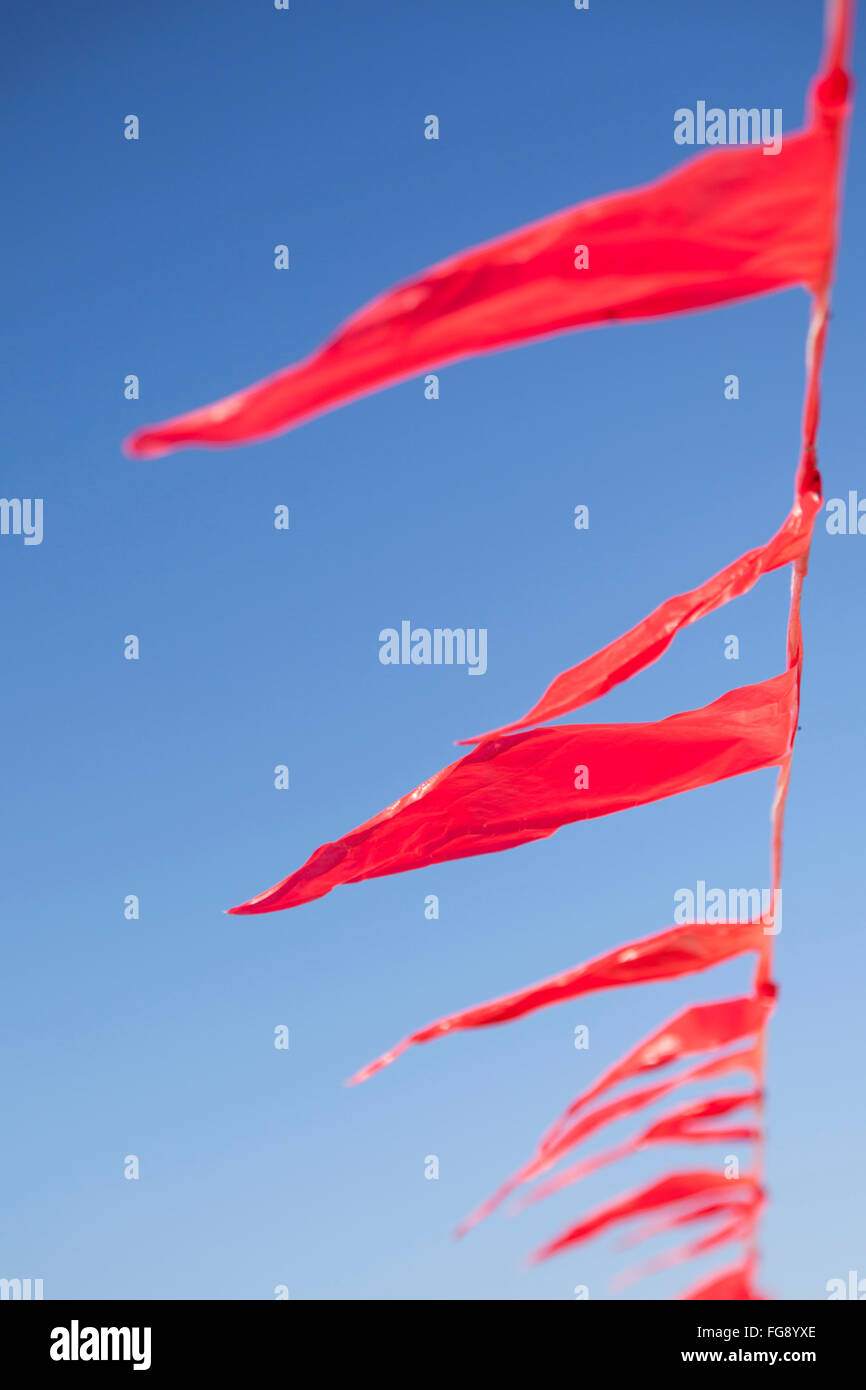Red Flag triangolare sopra beach in vento Foto Stock