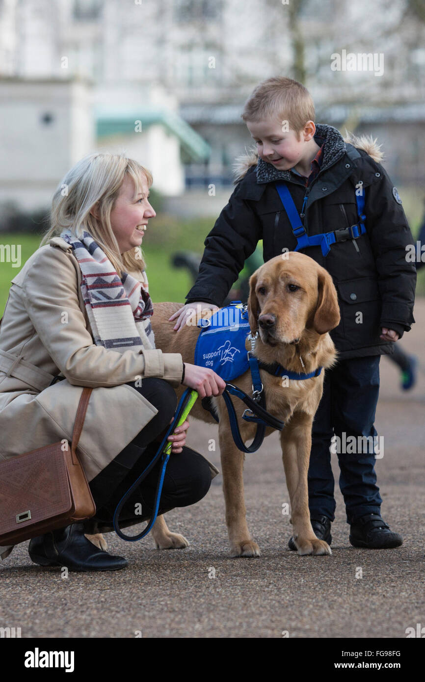 Londra, Regno Unito. Il 18 febbraio 2016. Cohen Hadfield, 7, da Rotherham, South Yorkshire con Azerley, un Golden Retriever croce, autismo cane di assistenza e sua mamma. Il Crufts 2016 cane eroi finalisti sono stati rivelati dal Kennel Club. L annuale Eukanuba Amici per la vita concorso gestito dal Kennel Club festeggia ispirando storie di cani compagnia di fronte alle avversità. © Immagini vibranti/Alamy Live News Foto Stock