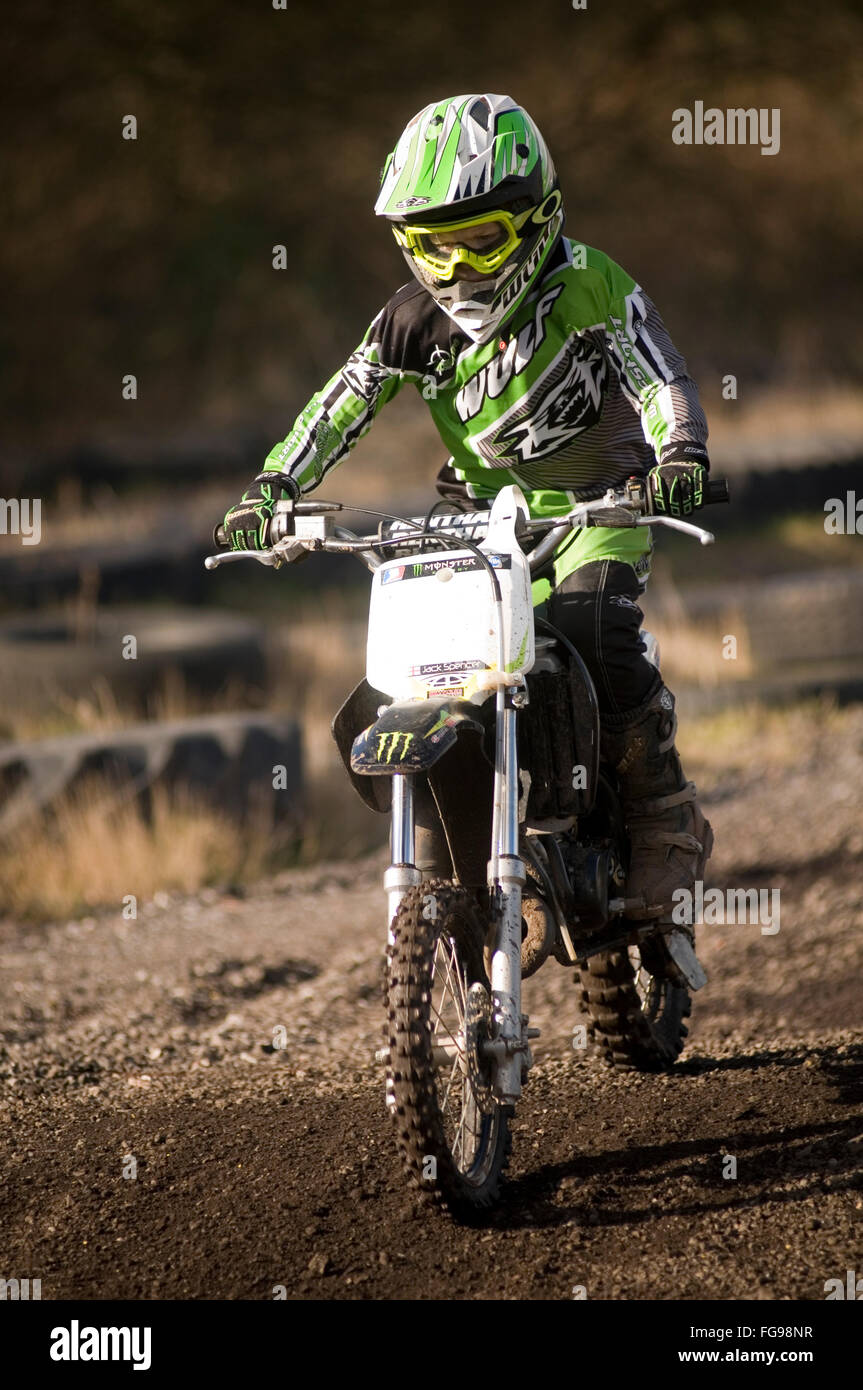 Junior moto cross X bambino cavaliere a cavallo di un motore di moto motocross moto off road scrambler cicli di scrambling cicli a motore in moto Foto Stock
