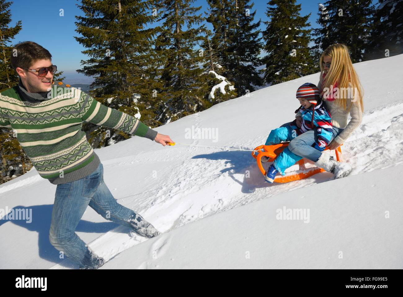 Famiglia avente il divertimento sulla neve fresca in vacanza invernale Foto Stock