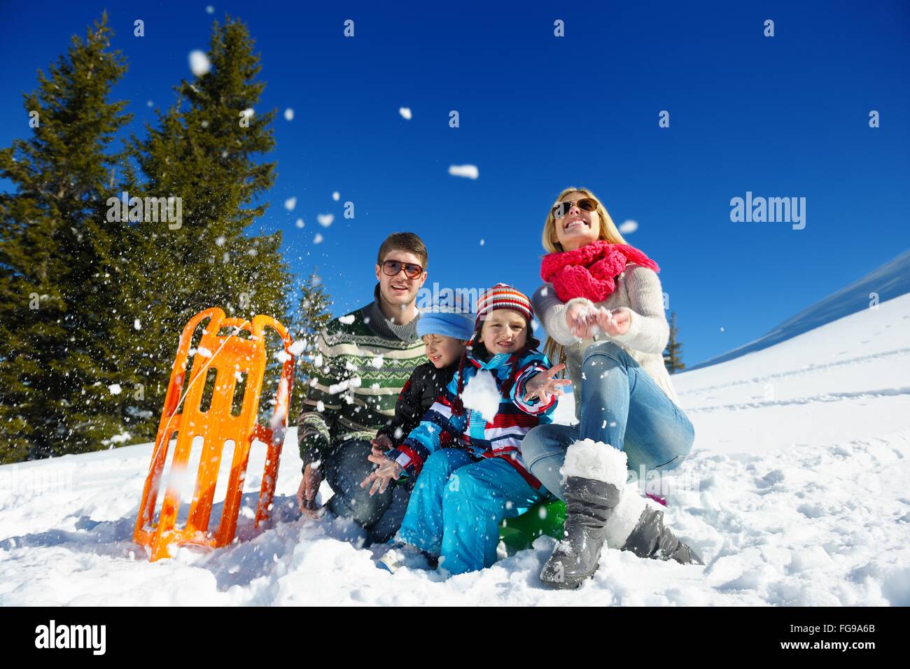 Famiglia avente il divertimento sulla neve fresca in inverno Foto Stock