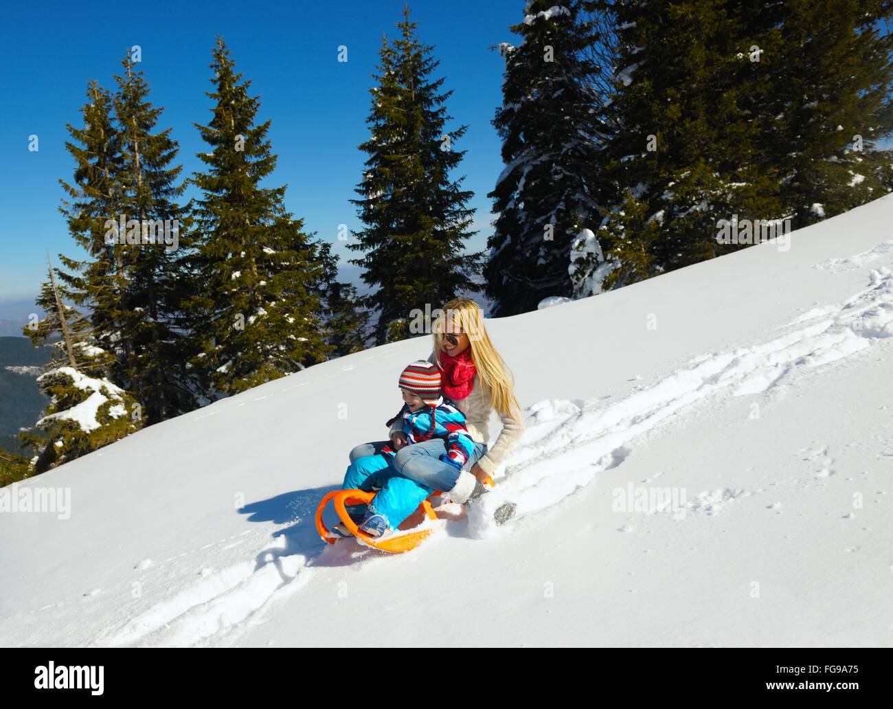 Famiglia avente il divertimento sulla neve fresca in inverno Foto Stock