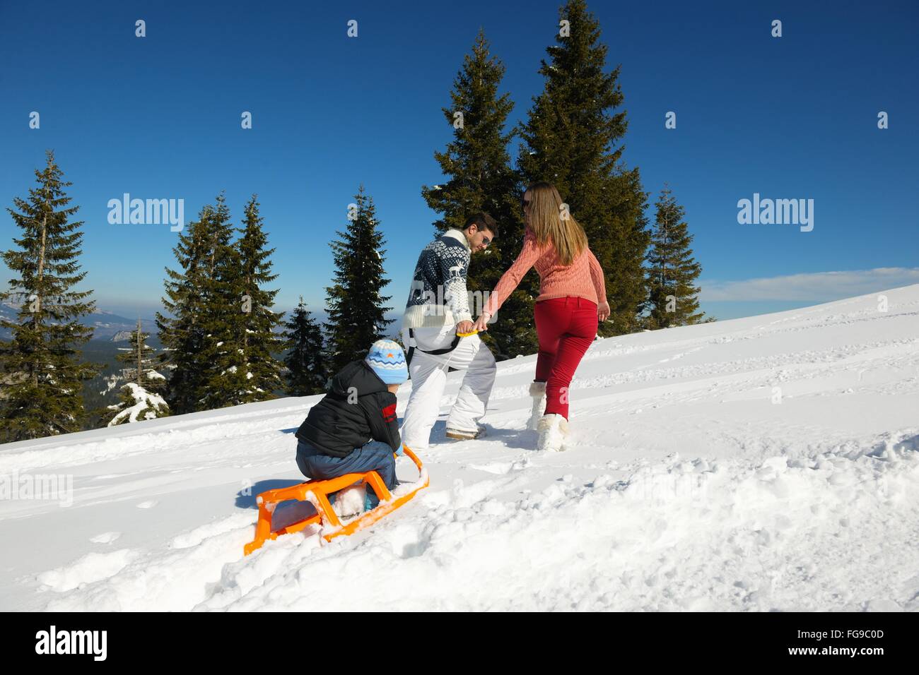 Famiglia avente il divertimento sulla neve fresca in inverno Foto Stock