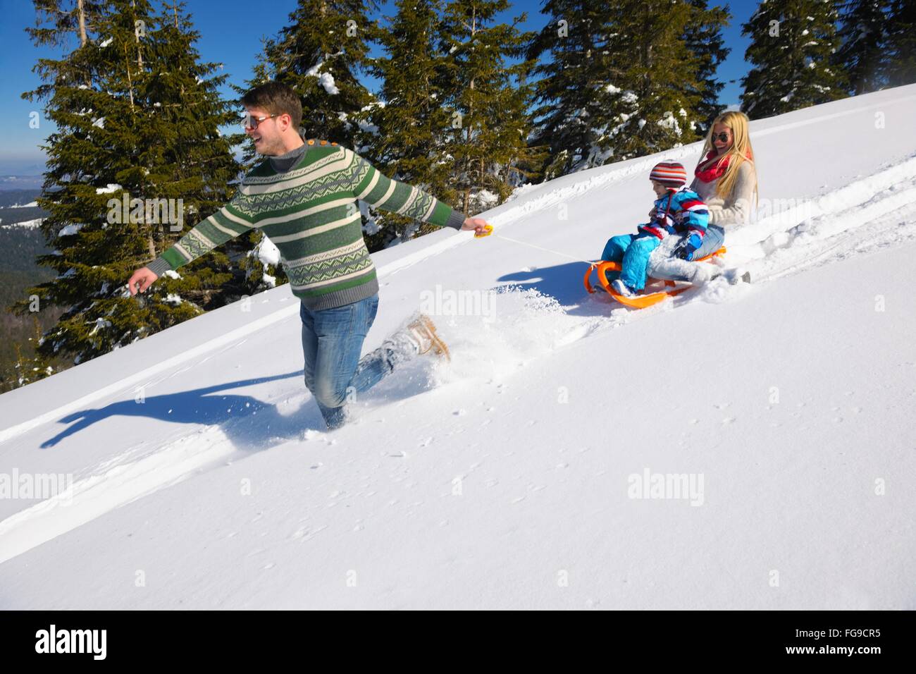 Famiglia avente il divertimento sulla neve fresca in vacanza invernale Foto Stock