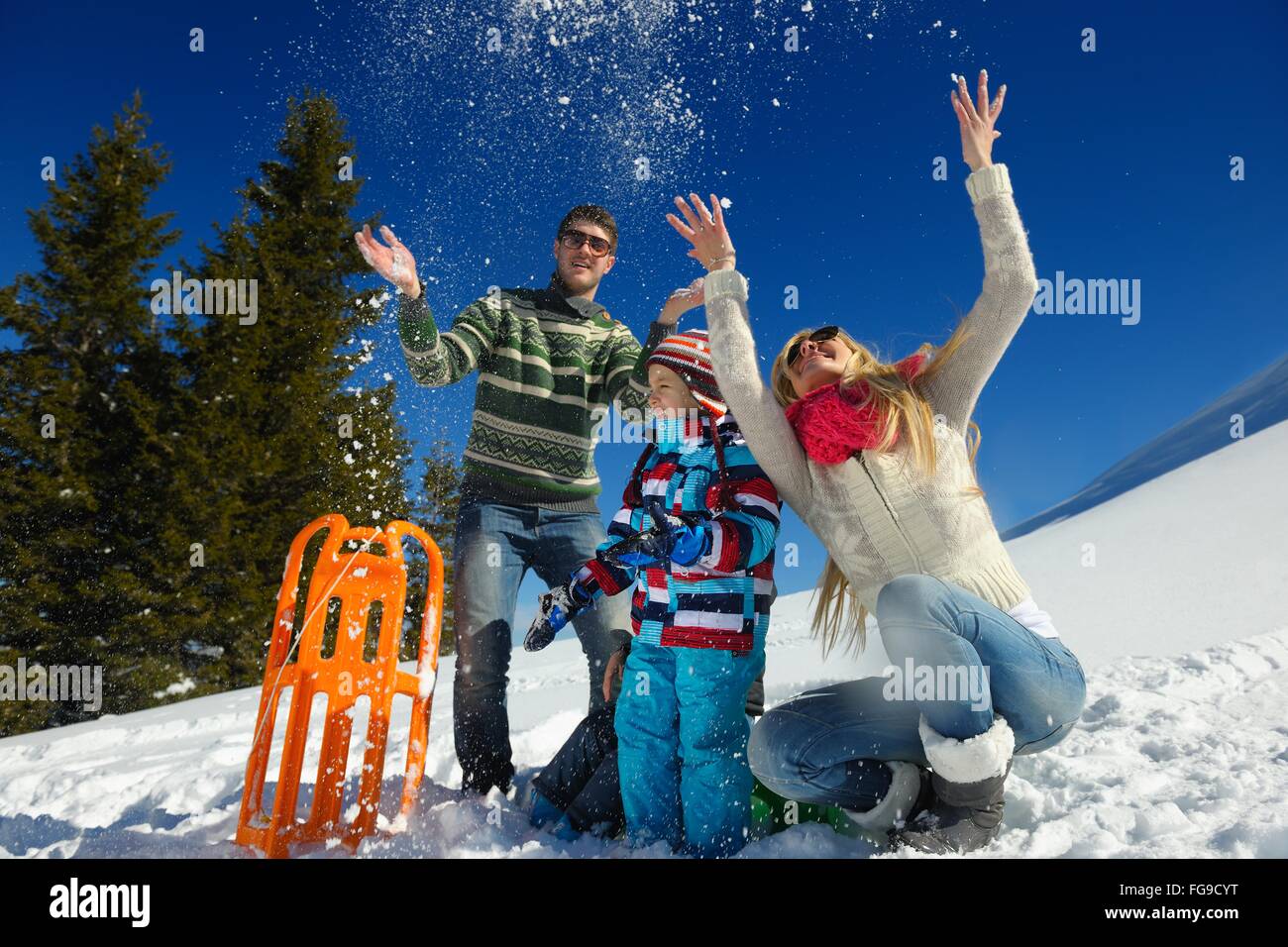 Famiglia avente il divertimento sulla neve fresca in vacanza invernale Foto Stock