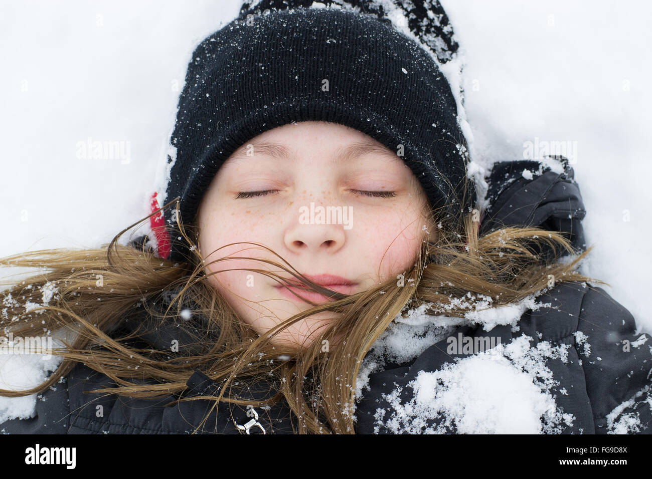 Ragazza distesa nella neve Foto Stock