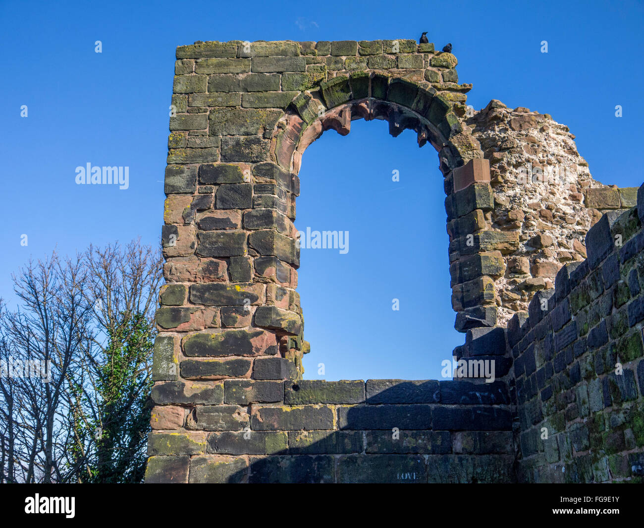 Arco in un castello in rovina la parete con un cielo blu. Foto Stock