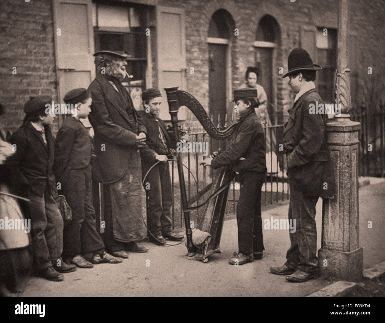La vita di strada a Londra dall'epoca vittoriana - musicista di strada con arpa Foto Stock