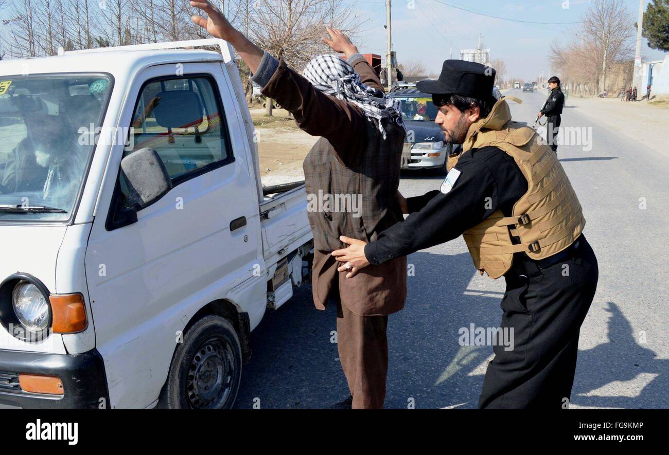 (160218) -- KUNDUZ, Feb 18, 2016 (Xinhua) -- un poliziotto afghano frisks un passeggero in un checkpoint di polizia nella provincia di Kunduz, Afghanistan settentrionale, Feb 17, 2016. Le forze di sicurezza afgane hanno assunto la piena sicurezza cariche dalla NATO e le forze degli Stati Uniti dopo la NATO-portato le truppe completato la loro missione di combattimento in Afghanistan entro la fine del 2014, dopo tredici anni di presenza militare nel paese. (Xinhua/Ajmal Kakar) Foto Stock