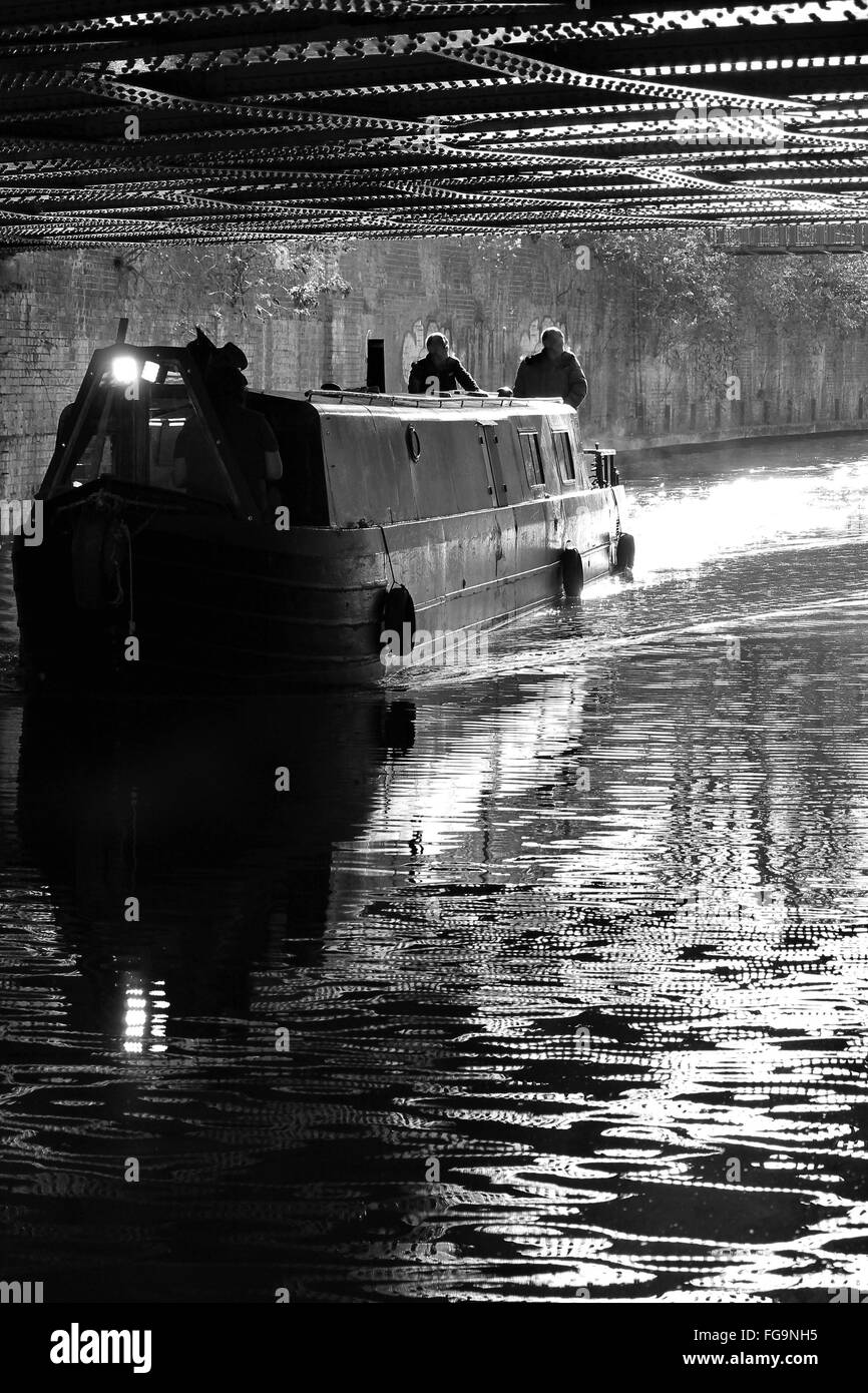 Regent's Canal, London Borough of Camden che corre attraverso Londra, canal barcone sul fiume passando sotto il ponte Foto Stock