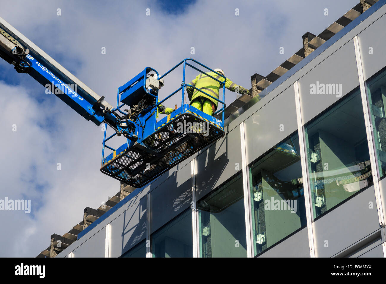 Due maschi lavoratori edili lavora in altezza durante la costruzione di opere su Università di Nottingham campus Foto Stock