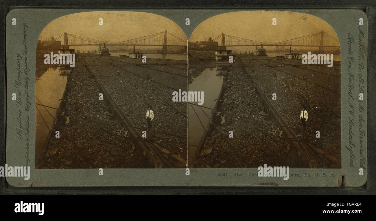 Una vista del commercio di carbone fluviale a Pittsburgh, Pennsylvania, mostrando chiatte di carbone e l'attività industriale lungo il fiume. L'immagine riflette la storica industria carboniera della città. Foto Stock