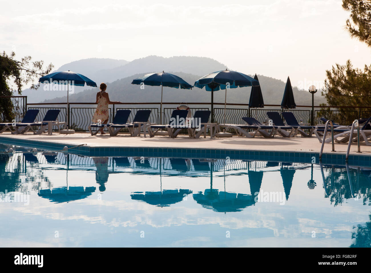 Una donna sta guardando la vista dal lato piscina balcone, Turchia. Foto Stock