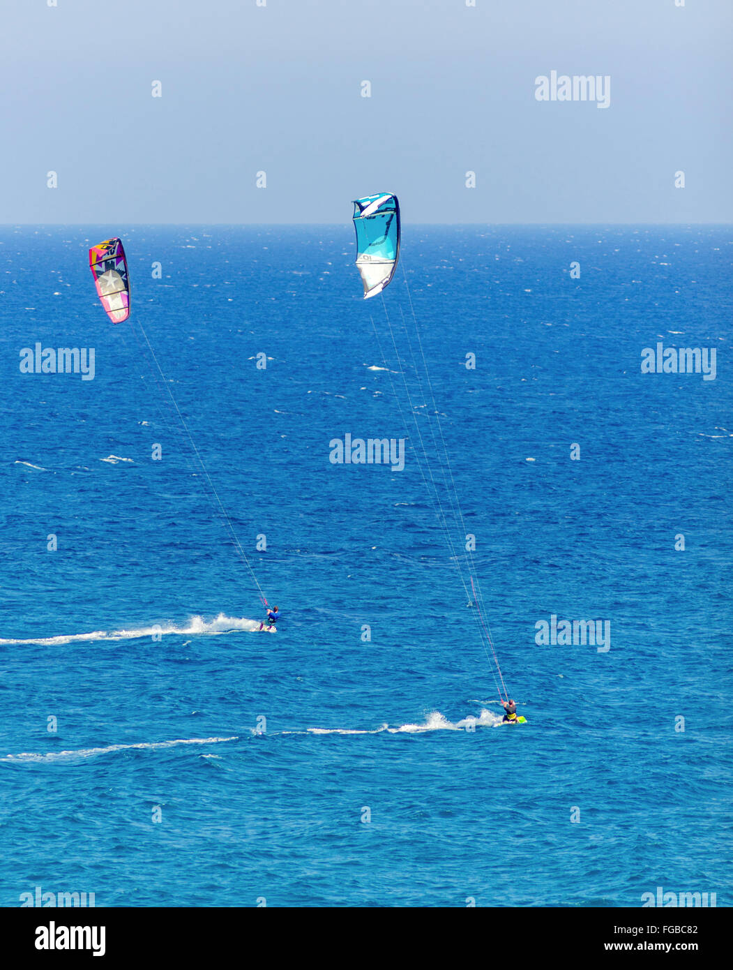 Due uomini di Kitesurf in cristallo baie di Cipro. Un sport acquatici per cui un kite surfer controlla una potenza kite e cavalca le onde su una Foto Stock