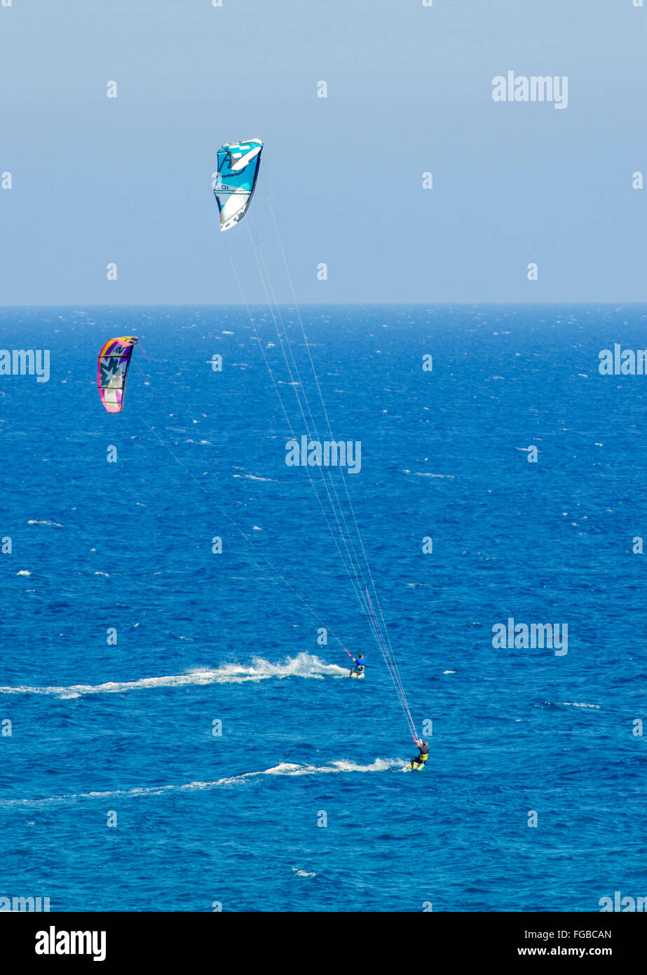 Due uomini di Kitesurf in cristallo baie di Cipro. Un sport acquatici per cui un kite surfer controlla una potenza kite e cavalca le onde su una Foto Stock